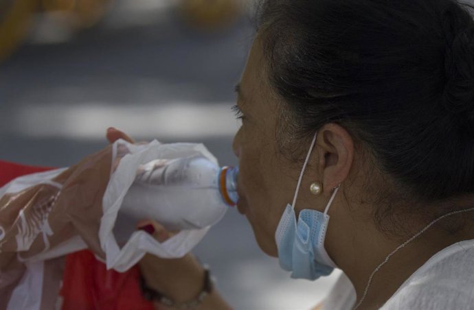 Una mujer bebiendo agua durante la ola de calor africano del pasado 30 de julio de 2020.