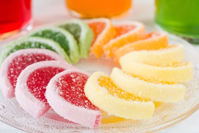 Colorful fruit jelly candies arranged in circle on wooden table.