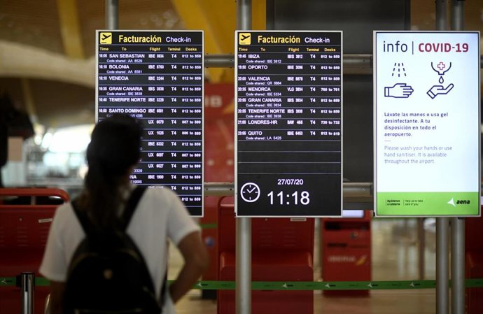 Un pasajero observa un panel de facturación en la terminal T1 del Aeropuerto Adolfo Suárez Madrid-Barajas