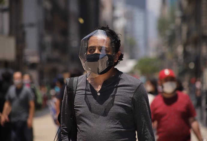 Un hombre camina por las calles de Ciudad de México con extra de protección contra el COVID-19.