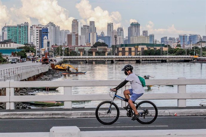 Un hombre en bicicleta con mascarilla en Manila