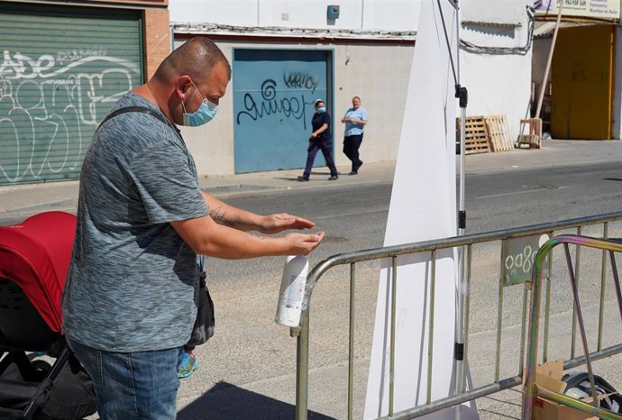Clientes se lavan las manos antes de entrar en un mercadillo, en una imagen de archivo