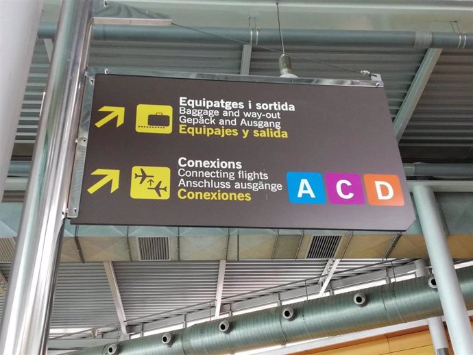Carteles de información en el aeropuerto de Palma indicando el camino hacia recogida de equipajes y terminales.