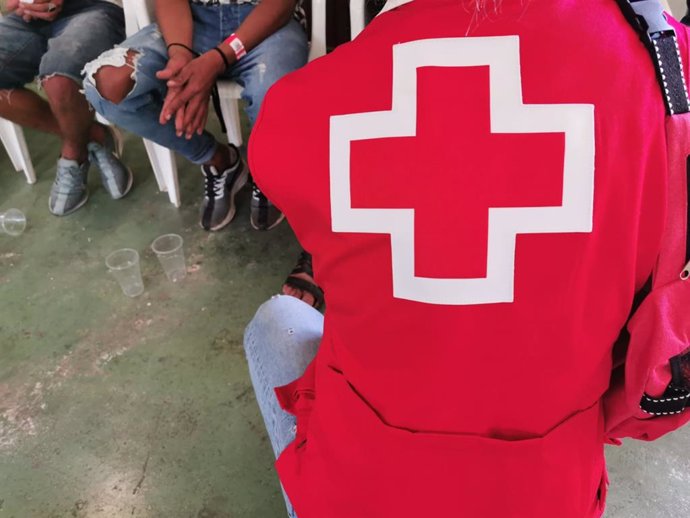 Un voluntario de Cruz Roja atiende a migrantes llegados en patera en una imagen de archivo
