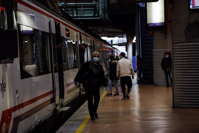 Pasajeros con mascarillas en el andén de la estación de cercanías Puerta de Atocha, en Madrid (España), a 13 de abril de 2020.