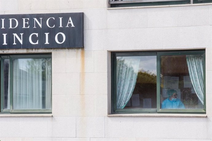 Una sanitaria en una ventana de la residencia de ancianos de O Incio, en Lugo (España), donde se ha detectado un brote de coronavirus.