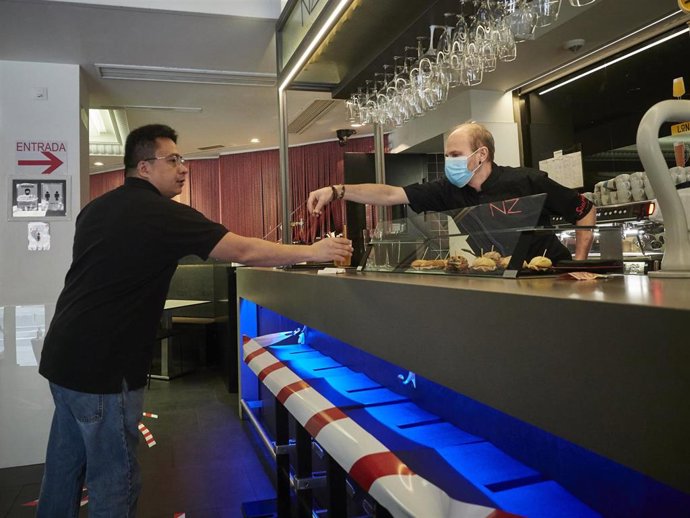 Un camarero en la barra de un bar