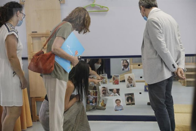 La vicealcaldesa de Madrid, Begoña Villacís (3i), observa unas fotografías en su visita a la Escuela Infantil Municipal Las viñas, en el distrito de Moncloa-Aravaca, en Madrid (España), a 30 de junio. Allí conocerá, junto al delegado del Área de Familia