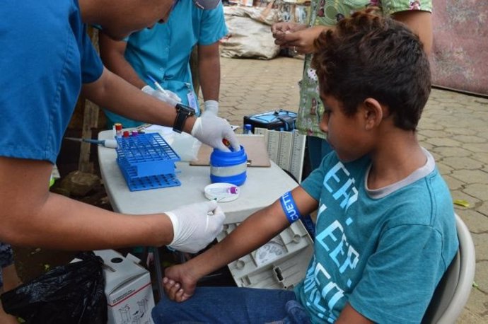 Un niño que participa en un estudio de cohorte longitudinal de enfermedades transmitidas por mosquitos en Managua, Nicaragua, presenta una muestra de sangre anual, como el zika o el dengue.