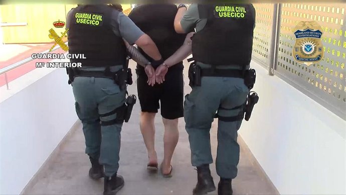 Agentes de la Guardia Civil se llevan esposado a uno de los detenidos en la 'Operación Pertinax'