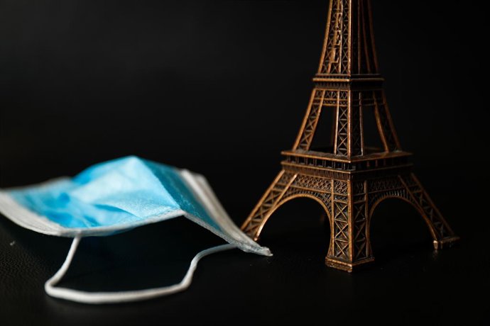 Un souvenir de la Torre Eiffel junto a una mascarilla quirúrgica