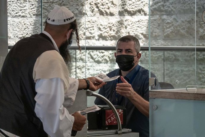 Un viajero entrega el pasaporte en el Aeropuerto de Ben Gurion