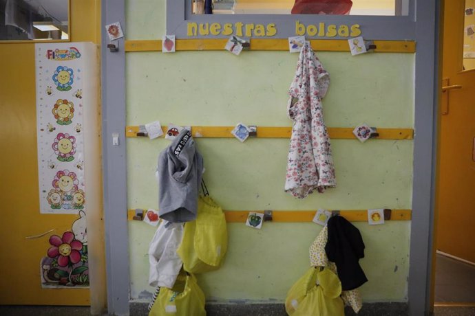 Chaquetas de los alumnos colgadas en la pared de una escuela infantil, foto de archivo
