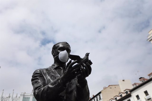 Estatua de Federico García Lorca con una mascarilla en la Plaza de Santa Ana tras la desconvocatoria del parón cultural de este fin de semana por la promesa de la portavoz del Ejecutivo, María Jesús Montero, de estudiar las singularidades de este sector p