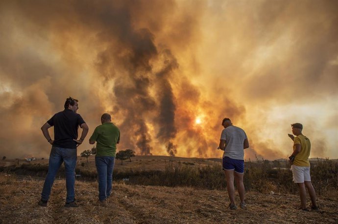 Vecinos observan el incendio forestal declarado en el Paraje Olivargas de Almonaster la Real (Huelva, Andalucía, España), a 27 de agosto de 2020.