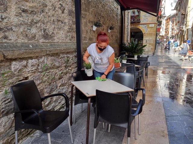 Una trabajadora desinfecta la terraza de un bar en Ermua (Bizkaia)