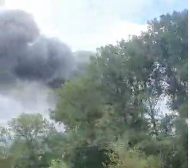 Columna de humo del incendio de una nave de motos del polígono de Silvota vista desde la autopista