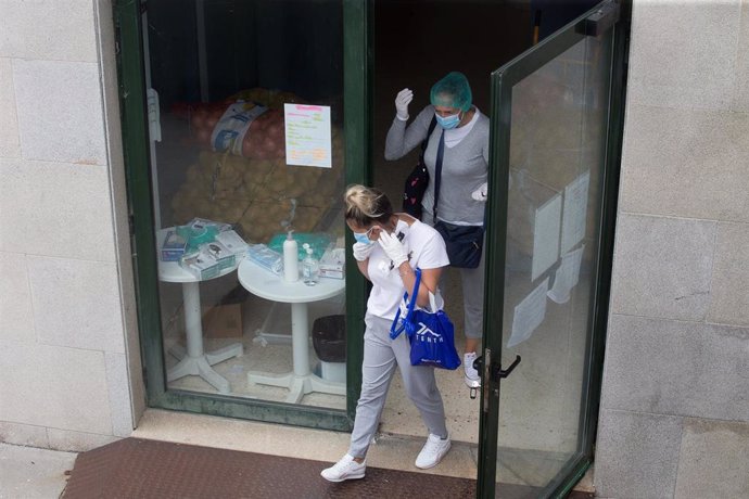 Dos mujeres a la entrada de la residencia de ancianos de O Incio, en Lugo (España), donde se ha detectado un brote de coronavirus, el 20 de agosto de 2020.