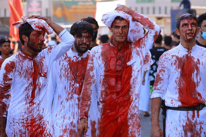 30 August 2020, Iraq, Baghdad: Shiite Muslims men with blood on their heads after hitting themselves with swords, take part in a ritual ceremony on the day of Ashura in Kadhimiya neighbourhood. Yom Ashura is the tenth day of Muharram, the first month in