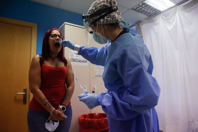 Una trabajadora sanitaria realiza una prueba PCR a una de las personas que ha acudido durante la jornada de hoy a realizarse un test al dispositivo instalado en el Centro de Especialidades El Arroyo, en Fuenlabrada, Madrid, (España), a 27 de agosto de 2