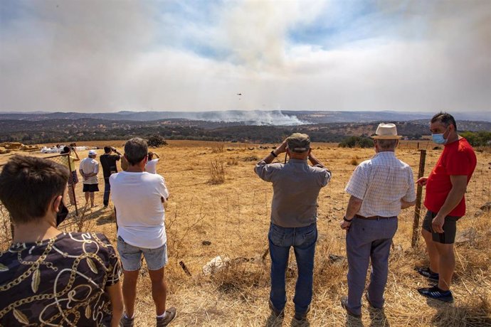 Vecinos de Zalamea la Real observan las labores de extinción del incendio forestal de Almonaster la Real (Huelva).