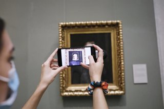 Una visitante saca una foto con el móvil a un cuadro del Museo del Prado el primer día de reapertura