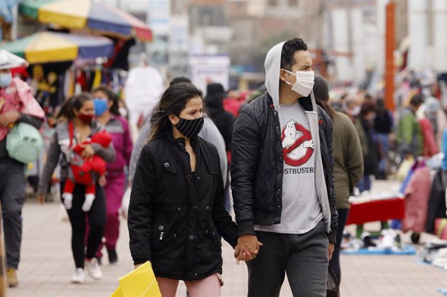Una pareja camina por uno de los mercadillos urbanos de Lima, la capital peruana.
