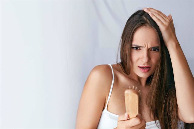 Hair Loss. Upset Woman Holding Brush With Hair. Pelo, caída de pelo, mujer ,injerto capilar