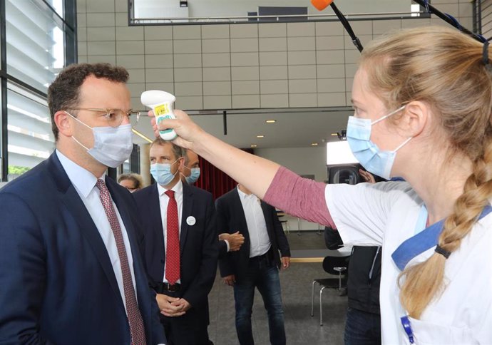 Una estudiante de medicina mide la temperatura al ministro de Sanidad alemán, Jens Spahn