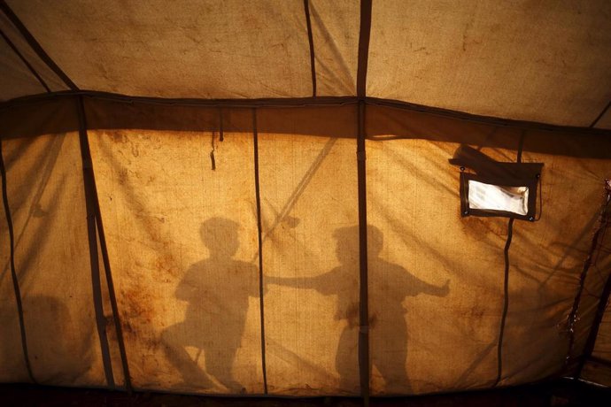 Sombras de dos niños refugiados en el campamento de Idomeni, en Grecia