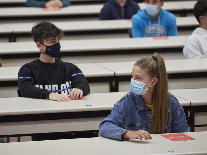Alumnos sentados a la distancia segura en el inicio de curso de una universidad. 