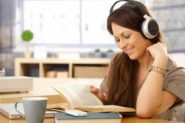 Happy woman with book and headphones