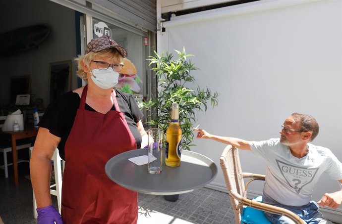 Una camarera y un cliente en un establecimiento de Calviá.