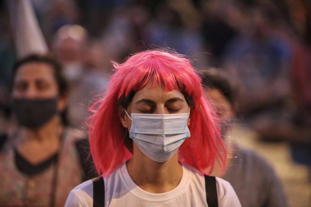 Una mujer israelí con mascarilla meditando en una manifestación contra el Gobierno en Jerusaléna