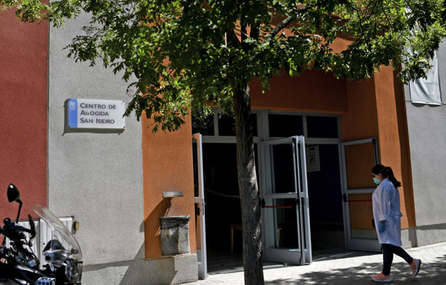 Una mujer con bata blanca entra en el Centro de acogida de San Isidro