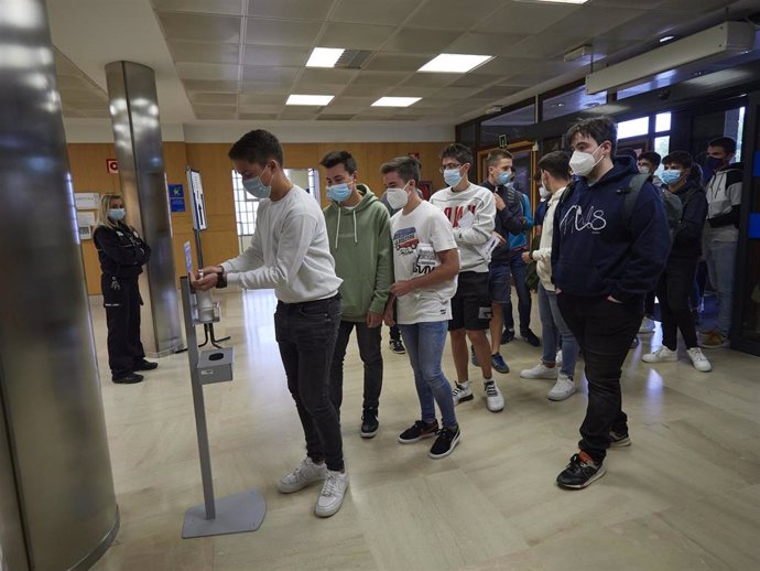 Alumnos de la UPNA se desinfectan las manos en un dispensador de gel hidroalcohólico a su entrada a las instalaciones de la Universidad el día en el que se celebra la apertura del curso 2020-2021, en Pamplona
