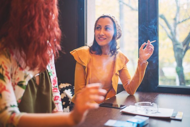 Mujeres fumando en un bar. Fumador social.