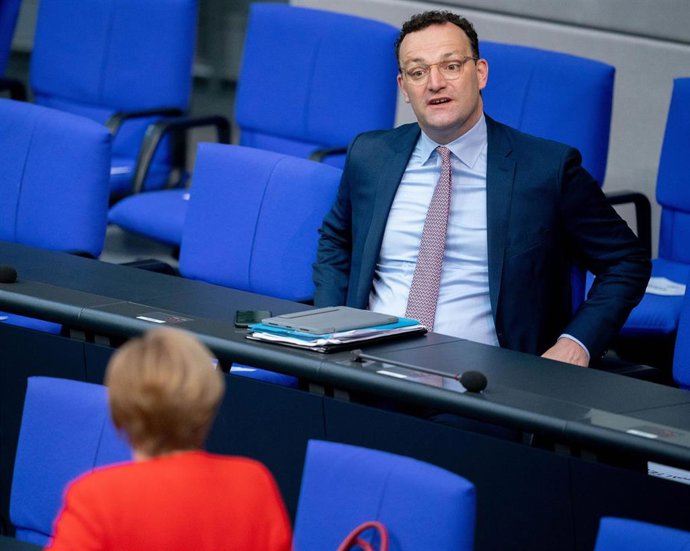Merkel habla con el ministro de Sanidad alemán, Jens Spahn, en el Bundestag