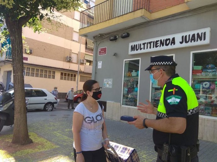 Un policía local de Córdoba habla con una ciudadana sobre el uso obligatorio de la mascarilla, en una imagen de archivo.