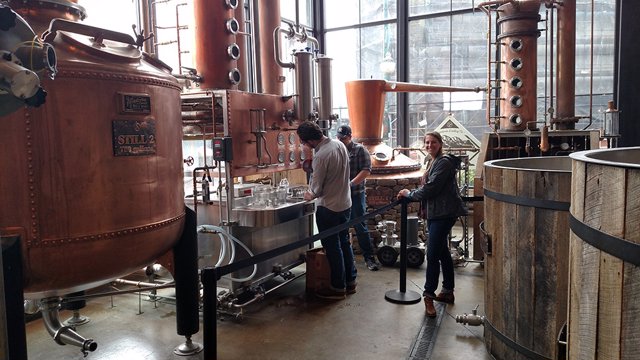 Estudiantes graduados del Departamento de Ciencias de los Alimentos de UT recolectando muestras de destilado de whisky para análisis químico en Sugarlands Distilling Company en Gatlinburg, Tennessee.