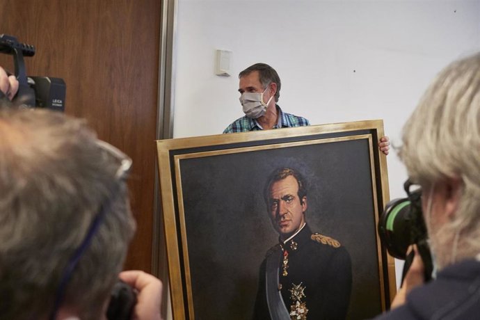Varios fotógrafos captan el momento en que un operario retira del retrato del rey emérito Juan Carlos I de la Sala de Gobierno del Legislativo foral del Parlamento de Navarra 
