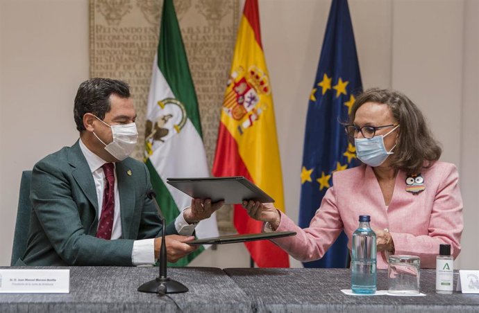 El presidente de la Junta de Andalucía, Juanma Moreno (i), durante la firma de convenio con la máxima mandataria de la Secretaría General Iberoamericana, Rebeca Grynspan (d), el primer convenio bilateral entre ambas instituciones. En el Palacio de San T