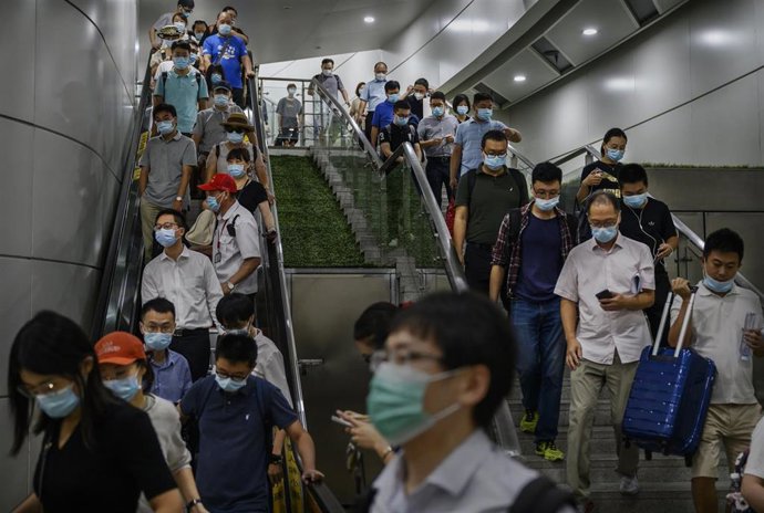 Personas con mascarilla en una estación de tren de Pekín