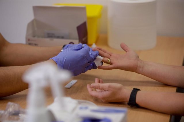Personal sanitario de Cruz Roja saca sangre de un dedo a una persona para realizar el test rápido de detección de anticuerpos IgG e IgM en el Instituto de Formación Integral en Seguridad y Emergencias (IFISE), en Colmenar Viejo, Madrid (España), a 2 de se