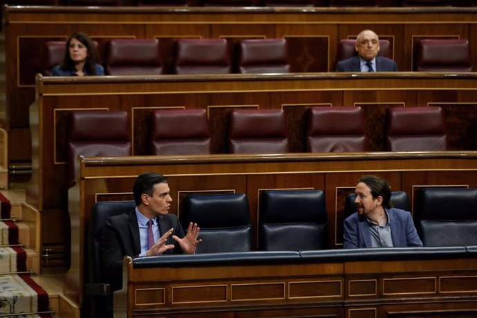 El presidente del Gobierno, Pedro Sánchez (i), conversa con el vicepresidente segundo, Pablo Iglesias, este miércoles, durante una sesión de control al Gobierno en el Congreso de los Diputados, en Madrid (España), a 29 de abril de 2020.