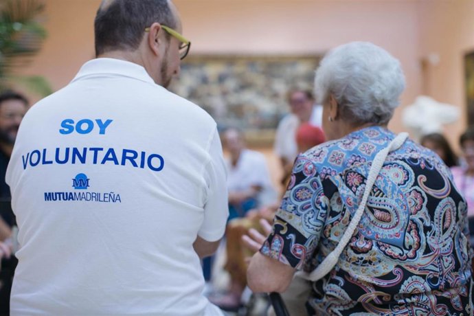 Un voluntario de la Fundación Mutua Madrileña con una anciana.