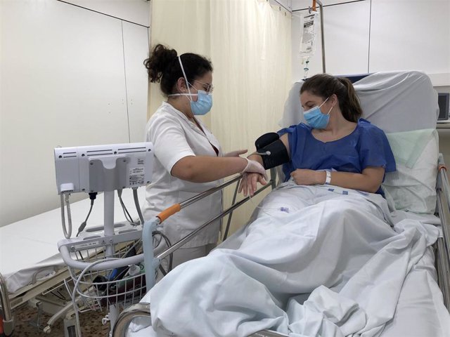 Profesional sanitaria atiende a una paciente en el Hospital Santa Caterina de Salt (Girona)
