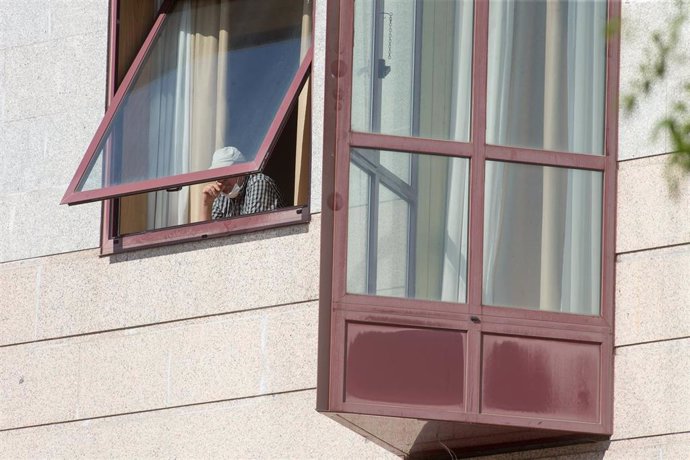 Una persona se asoma por la ventana de la residencia de mayores DomusVi de Outeiro de Rei en Lugo, Galicia (España).