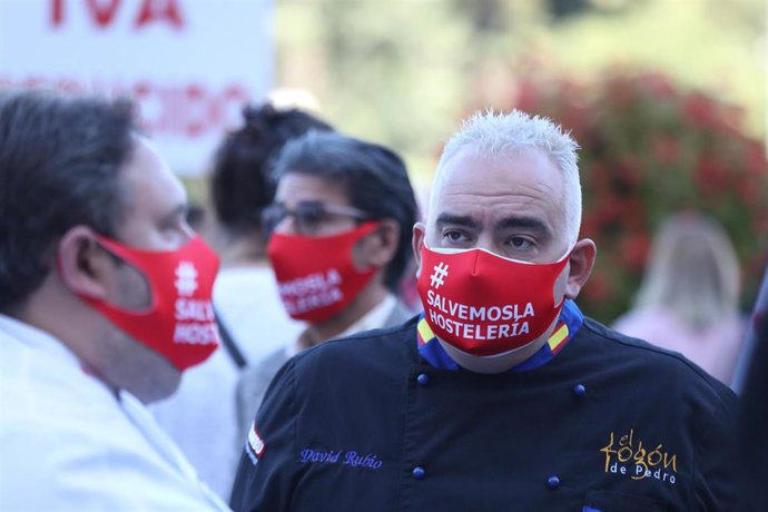 Un trabajadoro del sector de la hostelería con una mascarilla donde se puede leer "Salvemos la hostelería" 