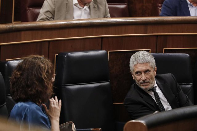 La ministra de Hacienda, María Jesús Montero, habla con el ministro del Interior, Fernando Grande-Marlaska, durante una sesión plenaria en el Pleno del Congreso en la que se votan las medidas de política social pactadas en el senado de la Comisión para la